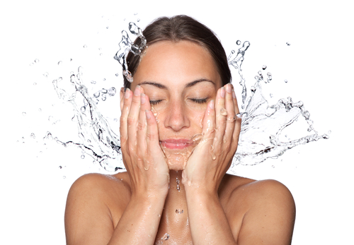 Lady cleansing or washing her acne-prone face