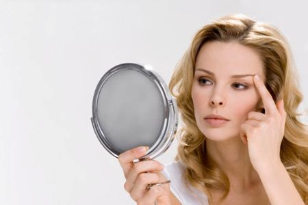 Lady in mirror looking at eye area